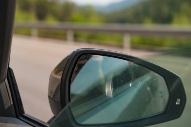 Arabayla seyahat, motorlu taşıtların camlarını açmak, arabanın içini havalandırmak, yaz tatili keyfi, yan ayna görüntüsü.