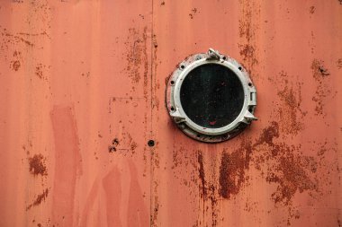 İtfaiye merkezini kapatın. Detayları kapatın. Eski, paslı, gemi pencereli bir duvar.