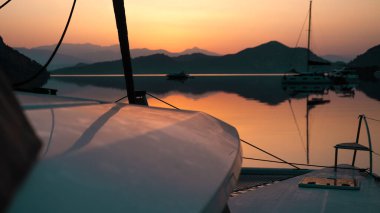 Sunrise ya da Sunset at anchor spot, harika deniz manzaralı yatlar, yelkenliler, alacakaranlık, parlak gökyüzü renkleri, dağ şeridi