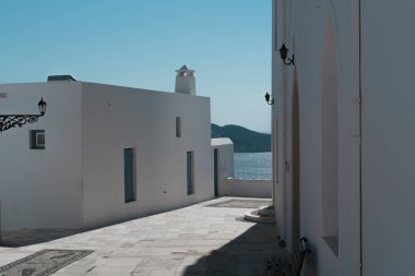 Milos 'taki Yunan kilisesinden deniz limanına, beyaz bina, mavi gökyüzü, seyahat yaygınlığı
