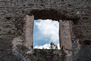 Terk edilmiş taş ev kalıntıları, mavi gökyüzü manzarası.