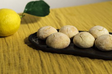 Parlak sarı limonlu buruşuk kurabiyeler ve limonlu mutfak tekstil peçetesi, rahat ev hayatı, ev yapımı fırın konsepti