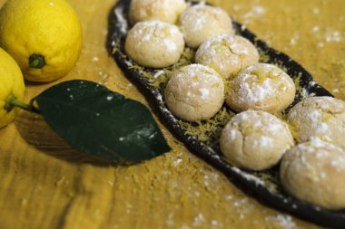 Parlak sarı limonlu buruşuk kurabiyeler ve limonlu mutfak tekstil peçetesi, rahat ev hayatı, ev yapımı fırın konsepti