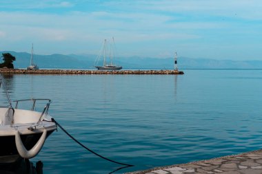 Paxos Yunan Adası 'ndaki Gaios limanının muhteşem manzarası, demirli tekneler, mavi deniz manzarası ve gökyüzü.