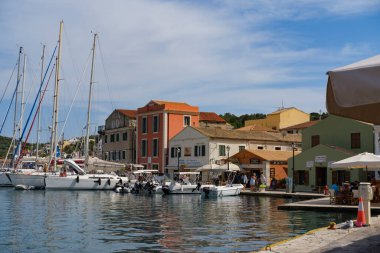 31 Mayıs 2024, Paxos Yunan Adası 'ndaki Gaios Limanı: Tekneler, dükkanlar ve tavernalarla rıhtımın ön cephesinde köy gezisi manzarası