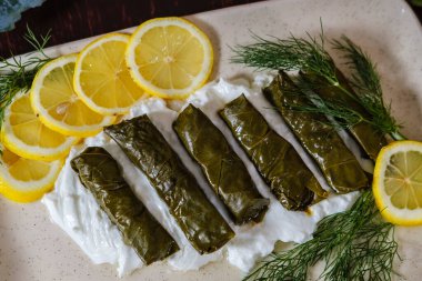 dolmades veya dolma adı verilen sarmaşık dolmades yaprakları, Türk ve Yunan geleneksel mutfağı sarması, yoğurt, limon ve yeşillik ile birlikte beyaz porselen tabakta servis edilir.