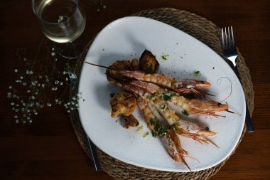 Lezzetli ızgara karides ve sarımsak sosu. Mantar ve beyaz şarap ile servis ediliyor.