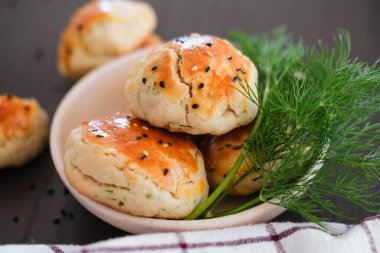 Türk usulü tatlı pogaca dereotu ve siyah susam veya kimyon, ev yapımı hızlı atıştırmalık.