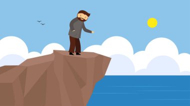 Bir adam denizin kıyısındaki uçurumda duruyor.