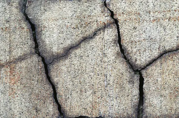 Çatlakları ve çizikleri olan taş bir duvarın dokusu arka plan olarak kullanılabilir.