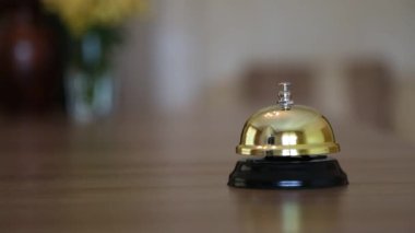 Bulanık bir arka planda siyah çanı olan bir elin yakın çekimi.