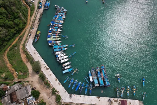 Yogya, Endonezya. 7 Kasım 2021. Mavi ve beyaz balıkçı tekneleri bir limana demir attı. Hava fotoğrafçılığı. Endonezya bir deniz ülkesi ve dünyanın en büyük balık üreticisi. Endonezya Limanı