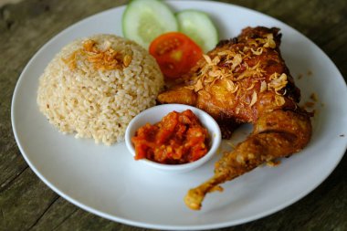 ayam bakar. Izgara tavuk, pilav, dilimlenmiş lahana, salatalık, fesleğen ve acı sos. Endonezya yemekleri.