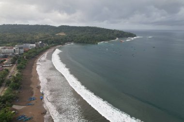 Sahildeki beyaz kumlu tropik plajın hava fotoğrafları. Temiz su plajı, yeşil tosca. Gunungkidul Yogyakarta Endonezya 'dan Pantai Ngrenehan.