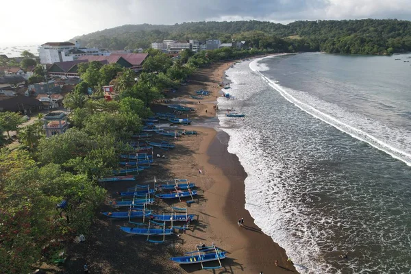 Beyaz kumlu tropikal plajın havadan çekilmiş fotoğrafı. Mavi balıkçı tekneleri kıyıda düzgün bir şekilde dizilmiş. Temiz su plajı, yeşil tosca. Gunungkidul Yogyakarta Endonezya 'dan Pantai Ngrenehan.