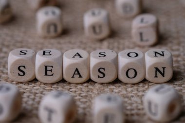 Season word concept on wooden cubes blocks on burlap background