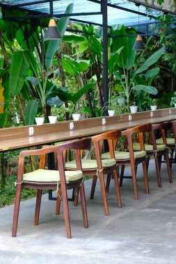 outdoor cafe interior with wooden table and chairs