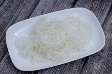 plate of cooked rice noodles on the wooden background