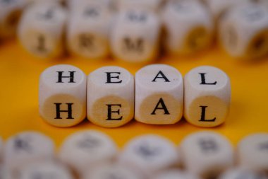 heal word concept on wooden cubes blocks on yellow background 