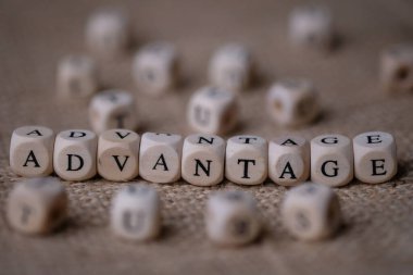 Advantage word concept on wooden cubes blocks on burlap background 