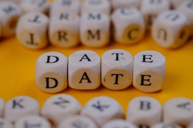 date word concept on wooden cubes blocks on yellow background 
