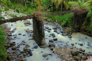 River in valley-shaped mountainous areas, with large rocks and murky water. Landscape in Indonesia. Tropical paradise. Rocky river.