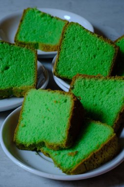 slices of green tea cake on white plates