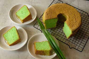 close up view of green pie on a cooling rack and its slices on a plates