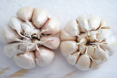 top view of garlic bulbs on white wooden background