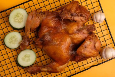Ayam Panggang. Whole roasted chicken with soy sauce and spices. on the cooling rack. Indonesian food.