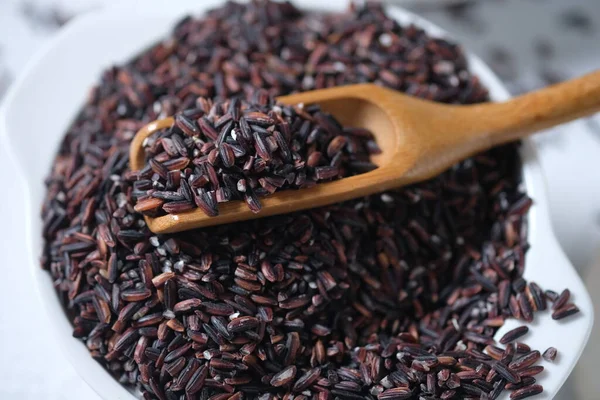 raw black rice in a white ceramic bowl