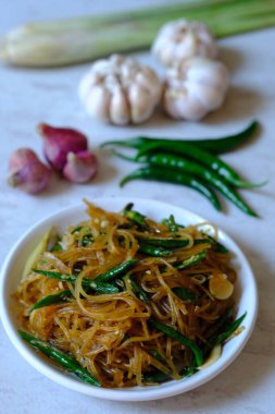 stir-fried noodles with green peppers on white plate 