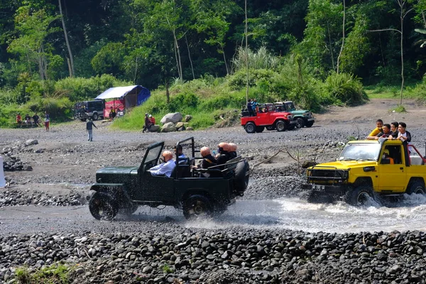 Yogyakarta, Endonezya - 19 Haziran 2022: Nehirde giden off-road jipleri. Endonezya 'nın doğal arazisinde 4x4 off-road araba macerası.