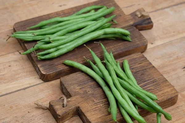 Green beans are known by many common names, including French beans, string beans, and snap beans or simply snaps on wooden board