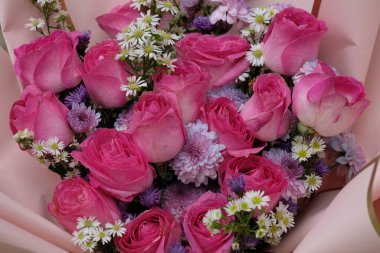 Güllerle, kasımpatılarla ve papatyalarla dolu çiçek demetlerini kapatın.