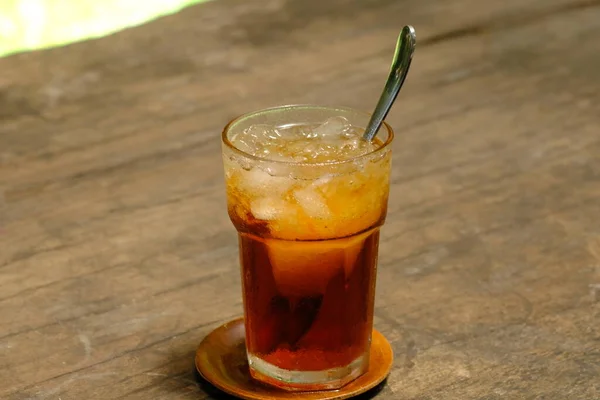 Teh 冰茶是用茶 糖和冰块制成的新鲜饮料 在褐色木制桌子上的透明玻璃杯里放着冰茶 印度尼西亚酒 — 图库照片