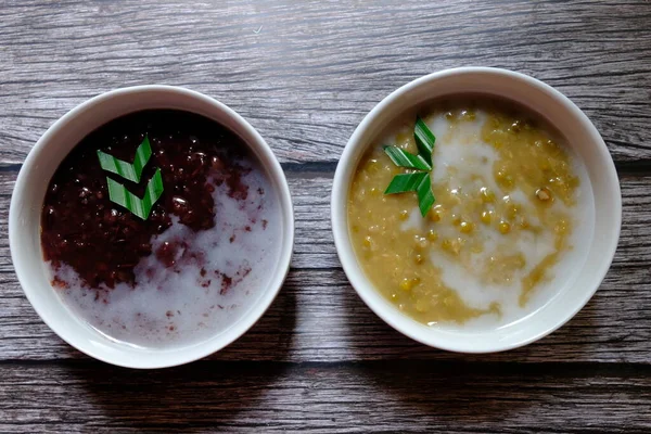 stock image Bubur Kacang Ijo or mung bean porridge and Bubur Mutiara or Mutiara Porridge are a famous meal from Indonesia. Made of mung bean, sugar, pandan leaf, and coconut milk. Top view.