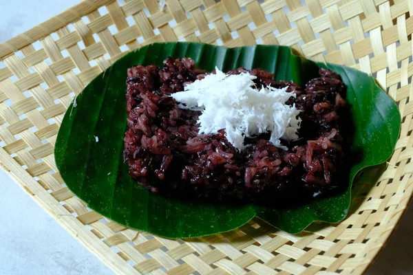 Ketan Hitam 은튀긴 끈적끈적 인도네시아 음식이며 그위에 과으깬 코코넛을 뿌린다 — 스톡 사진