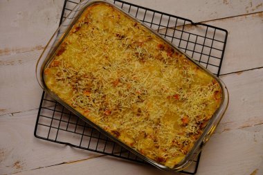 Schotel makarnası, makarna, yumurta, süt, sosis, peynir ve fırında pişirilen baharatlardan yapılan bir yemektir. Makarna, İtalya 'dan gelen bir yemektir. Tabak siyah mermer masada. en üstteki görünüm.