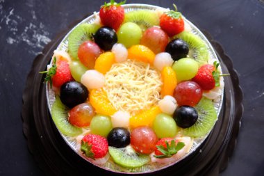 Taze meyve salatasıyla rendelenmiş peynir. Üzüm, çilek, kivi, liçi, meyve salatasında kavun, mayonez, yoğurt ve tatlandırılmış süt var. Taze ve sağlıklı çöller.