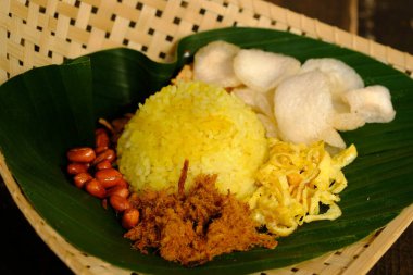 Nasi Kuning Endonezya 'nın geleneksel sarı pilavıdır, zerdeçal, hindistan cevizi sütü ve baharattan yapılır. Biftek, kraker, dilimlenmiş omlet, kızarmış fıstık ve muz yapraklı kızarmış tempeh ile servis edilir. Sokak yemeği..