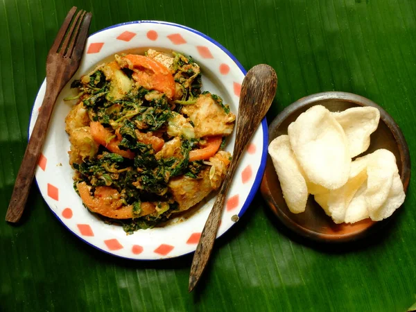 stock image lotek and crackers on a banana leaf. lotek is a Javanese salad made from boiled spinach, boiled long beans, boiled bean sprouts, cabbage, cucumber, tomatoes, and peanut sauce. Indonesian food.