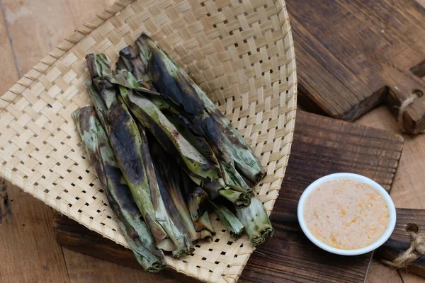 stock image Otak-otak tengiri bakar is processed mackerel fish wrapped in banana leaves, then grilled on coals. peanut sauce. Indonesian food.