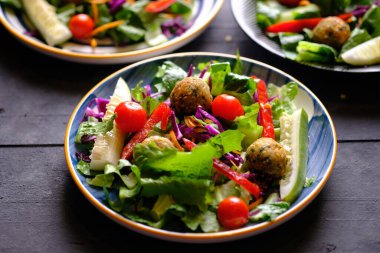 Salata de Falafel, salata, salatalık, soğan, kiraz domatesleri, zeytin, güneşte kurutulmuş domates ve fetadan oluşur. Falafel, kızartılmış bir top veya bezelyeden yapılmış köfte şeklinde börek türüdür..