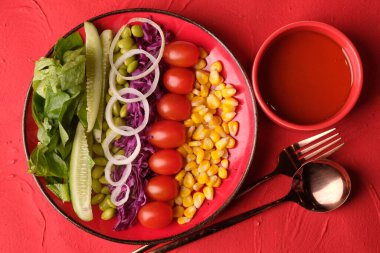 Taze sebze salatası, edamame, tatlı mısır, kiraz domatesleri, romaine marulu, dilimlenmiş salatalık, dilimlenmiş soğan ve mor. Düşük kalorili sağlıklı yiyecekler. Diyet için uygun. Ekstra saf zeytinyağı. Aperatif