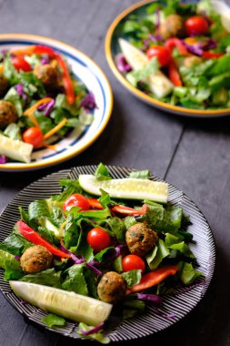 Salata de Falafel, salata, salatalık, soğan, kiraz domatesleri, zeytin, güneşte kurutulmuş domates ve fetadan oluşur. Falafel, kızartılmış bir top veya bezelyeden yapılmış köfte şeklinde börek türüdür..