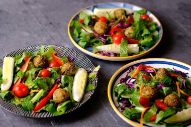 Salata de Falafel, salata, salatalık, soğan, kiraz domatesleri, zeytin, güneşte kurutulmuş domates ve fetadan oluşur. Falafel, kızartılmış bir top veya bezelyeden yapılmış köfte şeklinde börek türüdür..