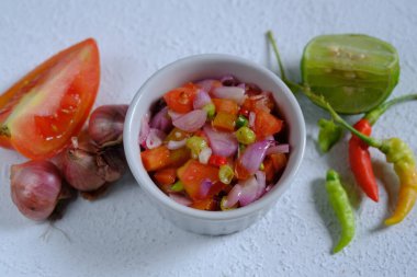 Sambal Dabu-dabu, Kuzey Sulawesi veya Manado şehrinde bulunan taze domates, kırmızı biber, dilimlenmiş arpacık soğanı, limon suyu, tuz ve yağdan yapılan tipik bir biber sosudur. Endonezya yemekleri.