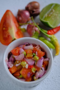 Sambal Dabu-dabu, Kuzey Sulawesi veya Manado şehrinde bulunan taze domates, kırmızı biber, dilimlenmiş arpacık soğanı, limon suyu, tuz ve yağdan yapılan tipik bir biber sosudur. Endonezya yemekleri.