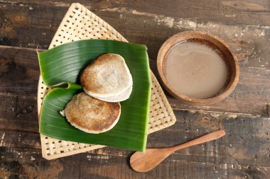 Serabi Surabi Kocor pirinç unu, hindistan cevizi sütü, pandanus yaprağı ve palmiye şekerinden yapılan geleneksel Java atıştırmalıklarıdır. Tahta masada bambu dokuma sepetinde servis ediliyor. Düz yatıyordu. Endonezya yemekleri.